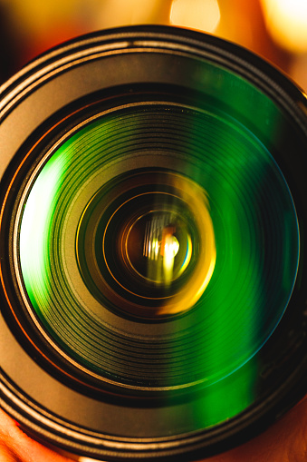 Abstract macro image depicting reflection and refraction on the front glass element of a camera lens.