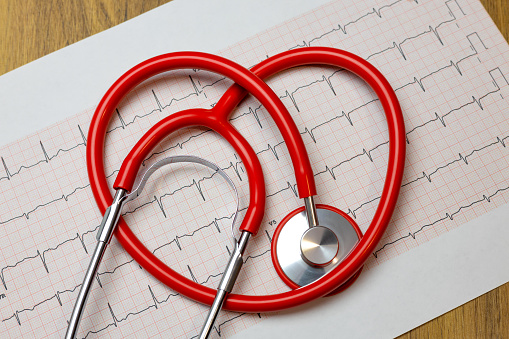 close-up of red heart stethoscope on electrocardiogram (ECG) paper