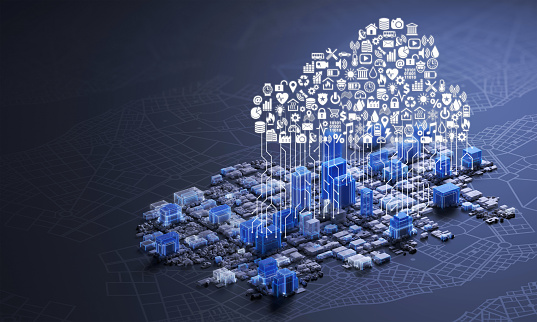 Aerial view of an abstract smart city with a cloud of symbols, apps and services connecting the buildings, illuminated by white and blue glowing lights. Concept for internet of things, BIM, cloud services and computing, facility management, urban planning. Dark background with diagram and city map, copy space on left side.