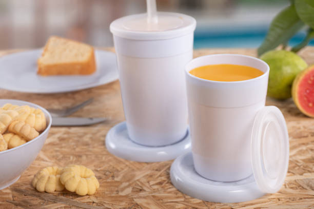 istock Breakfast table with juice. Colorful cups and plates 1457412733