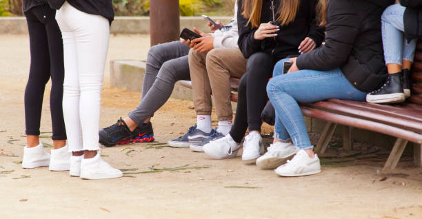 Group of young people sitting on a bench. stock photo