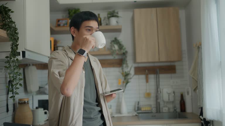 Disabled man holding a smartphone and drinking coffee before going to work