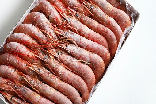 Frozen Argentinian king prawns isolated on white background. Directly above.