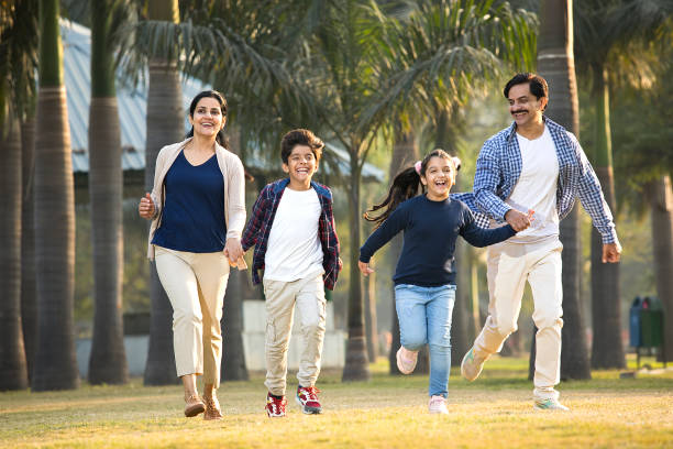 szczęśliwa, wielopokoleniowa rodzina biegająca w parku - offspring family love india zdjęcia i obrazy z banku zdjęć