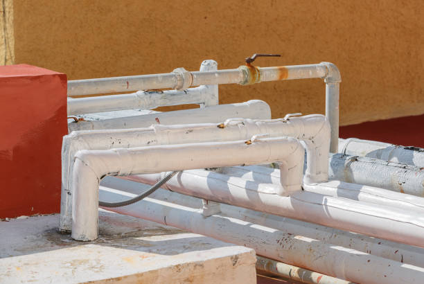closeup view of worn out pipes, tubes on a building roof stock photo