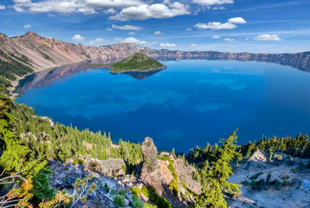 Crater Lake and Wizard Island Crater Lake exists in the blown-out caldera of a once mighty volcano known as Mount Mazama.  This view of the lake and Wizard Island was taken from the Rim Trail in Crater Lake National Park, Oregon, USA. jeff goulden crater lake national park stock pictures, royalty-free photos & images