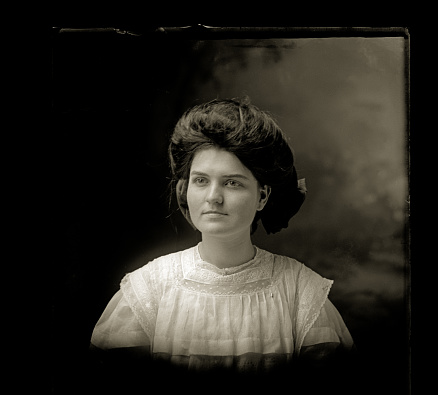 Beautiful Black and White close up portrait of a young woman wearing Victorian-era clothing. The image was digitally restored from a glass plate taken circa 1890.