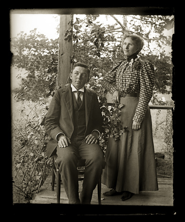Beautiful Black and White portrait of an married couple wearing Victorian-era clothing. Taken on the front porch of their farmhouse dressed in their best clothes. The image was digitally restored from a glass plate taken circa 1890.