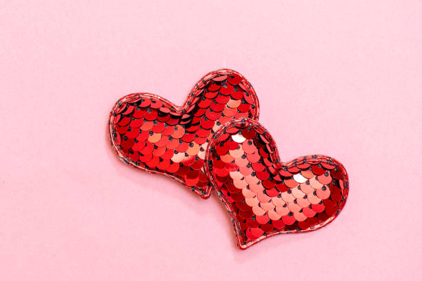 istock Two red hearts together on a pink surface. Love concept. 1457424644