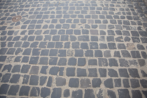 Paving stone background. Cobblestone Street. Grey granite cobblestoned pavement. Natural background.
