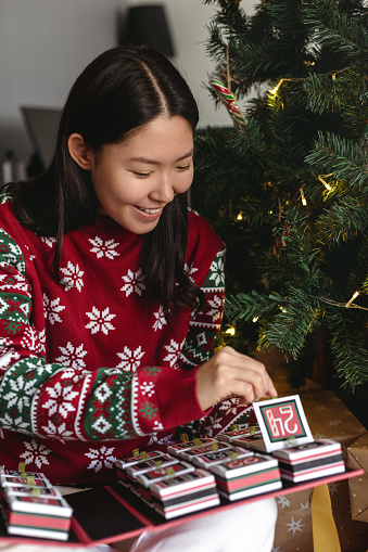 Young adult woman holding original advent calendar. Christmas diy craft