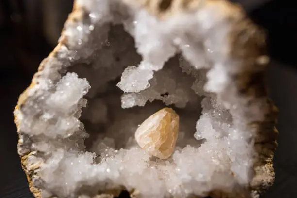 Illuminated detail shot of a hand-polished calcite, inside a crystal quartz druze.