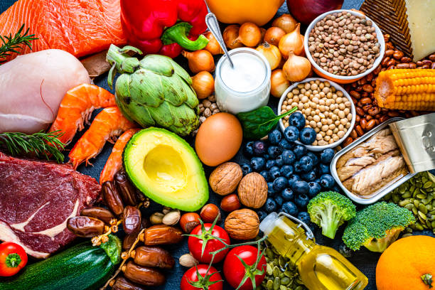 Overhead view of a large group of healthy raw food for flexitarian mediterranean diet. The composition includes salmon, chicken breast, canned tuna, cow steak, fruits, vegetables, nuts, seeds, dairi products, olive oil, eggs and legumes. High resolution 42Mp studio digital capture taken with SONY A7rII and Zeiss Batis 40mm F2.0 CF lens