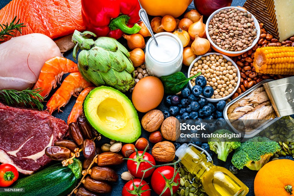 Group of healthy food for flexitarian diet Overhead view of a large group of healthy raw food for flexitarian mediterranean diet. The composition includes salmon, chicken breast, canned tuna, cow steak,  fruits, vegetables, nuts, seeds, dairi products, olive oil, eggs and legumes. High resolution 42Mp studio digital capture taken with SONY A7rII and Zeiss Batis 40mm F2.0 CF lens Healthy Eating Stock Photo