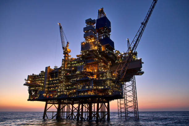 해질녘 바다의 해양 석유 및 가스 플랫폼. 
바다에서 원유 생산을 주도하십시오. - derrick crane drilling rig well sky 뉴스 사진 이미지