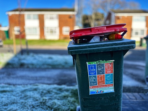 A bin and a letterbox in the snow at the roadside
