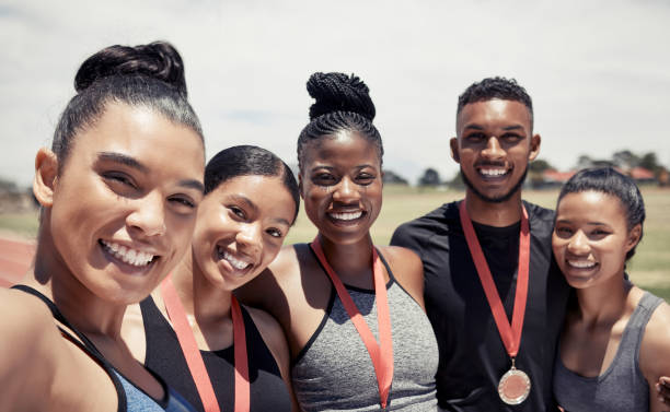 équipe féminine, masculine et de course à pied avec des médailles en fitness, entraînement ou marathon d’entraînement, épreuve de sprint ou course de compétition. portrait, sourire heureux ou coureurs gagnants avec prix sportif ou prix d’exerci - marathon running motion track event photos et images de collection