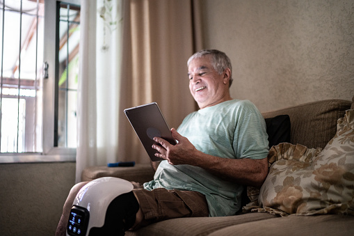 Senior man using digital tablet in sofa at home