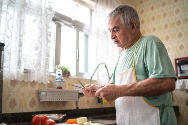 istock Senior man sharpening knife in kitchen at home 1457441019