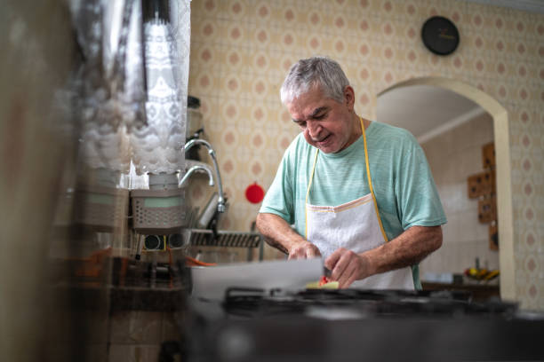 istock Senior man cutting vegetables on the chopping board in kitchen at home 1457442017
