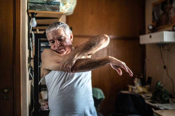 istock Senior man stretching arms at home 1457442096