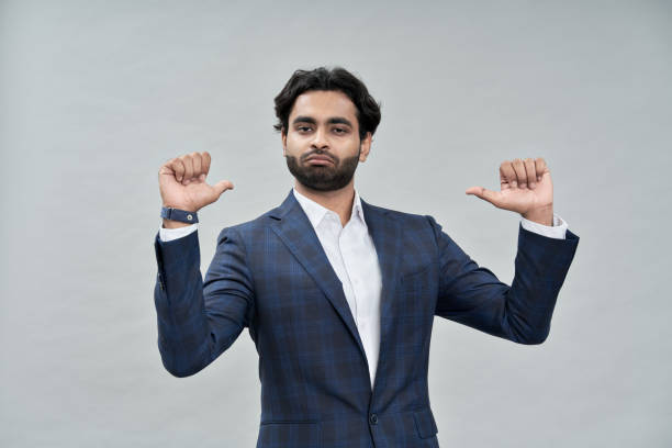 Confident indian arab business man isolated on beige pointing at himself.