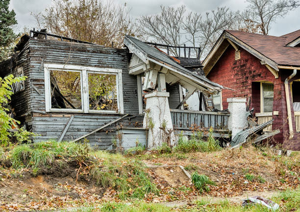 Ruins Of A Blue Home In Detroit The ruins of a home in a Detroit neighborhood show a collapsed roof through the front windows highland park michigan stock pictures, royalty-free photos & images