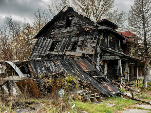 Burnt Remains Of Arson In Detroit The blackened remains of a burned out house shows the effect of arson in a neighborhood of Detroit. highland park michigan stock pictures, royalty-free photos & images