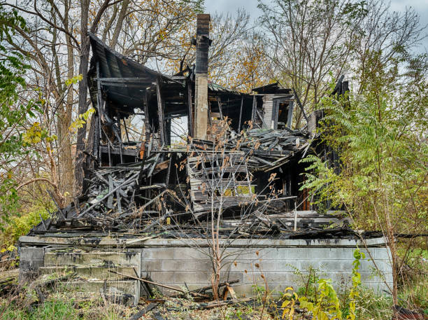 Home Foundation With Burned Out House A burned out house in Detroit, Michigan is perched on a concrete block foundation. highland park michigan stock pictures, royalty-free photos & images