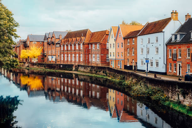 vista de la calle con coloridas casas de ladrillo cerca del río en la pequeña ciudad inglesa de norwich, inglaterra en otoño. edificios adosados frente al mar. casas de suburbios, edificio residencial cerca del río en europa. - norfolk england fotografías e imágenes de stock
