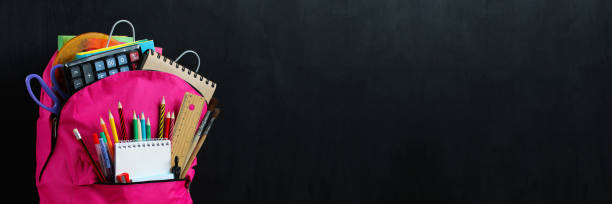 istock a school banner with a pink backpack and 
school stationery on the empty school blackboard. 1457449928