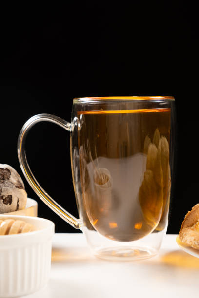 istock A cup of strong black tea, a glass large cup with a double bottom on a black background. 1457450809