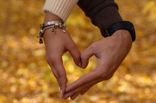 a couple in love shows a heart with their hands