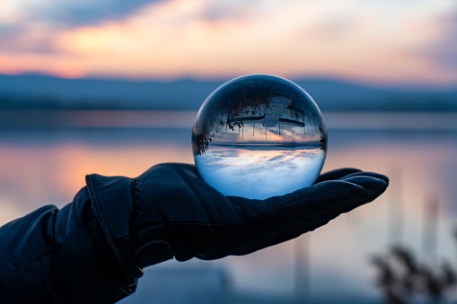 Close-up Of Businessman Predicting Future With Crystal Ball At Desk