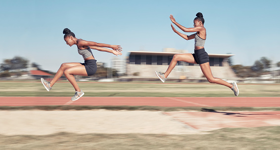 Time lapse, long jump and woman running, jumping and cross in sand pit for fitness, training and exercise. Sequence, jump and black woman jump, fit and workout, energy and sports practice at stadium