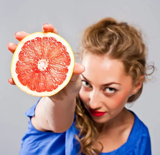 Beauty portrait of  young, attractive woman with grapefruit