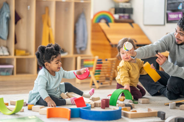 istock Male Daycare Educator with Children 1457453225