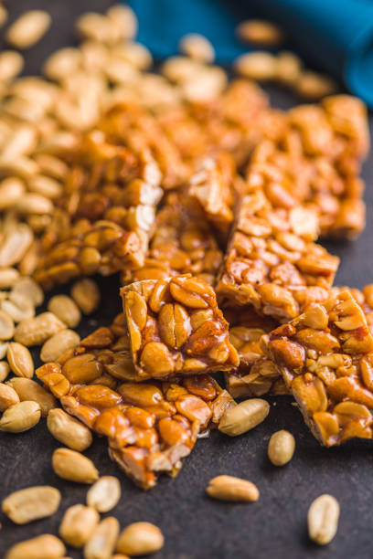 istock Sweet peanut brittle. Tasty peanuts in caramel on kitchen table. 1457453335
