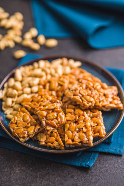 istock Sweet peanut brittle. Tasty peanuts in caramel on plate. 1457453345