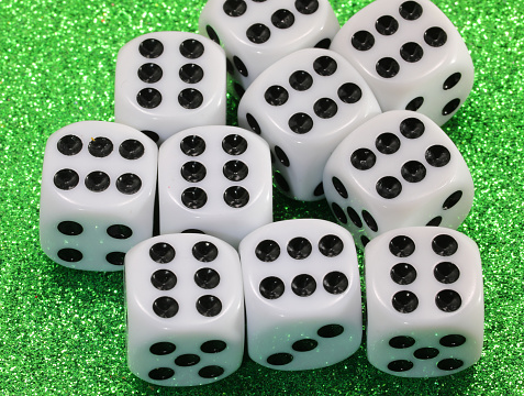many gambling dice on green shiny casino table