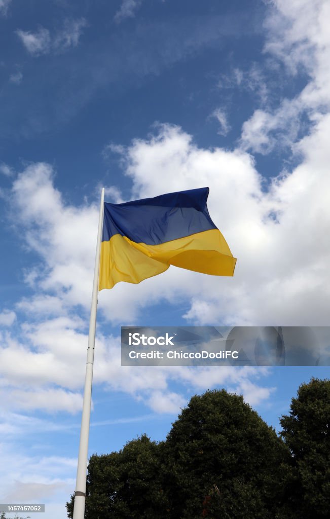 yellow and blue flag of Ukraine and sky with clouds in background yellow and blue flag of Ukraine and sky with white clouds in background Color Image Stock Photo