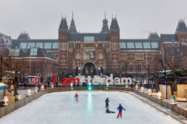 Amsterdam, Netherlands - May 7, 2017: The Rijksmuseum in Amsterdam, Netherlands, with a large pond in the foreground and the sign I amsterdam in the background.