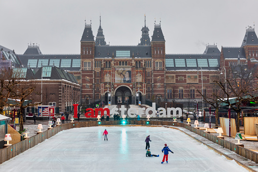 Ice rink Rijksmuseum on a bright day during winter in the netherlands. The ice rink is a winter fest in december en January on Museumplein, Amsterdam