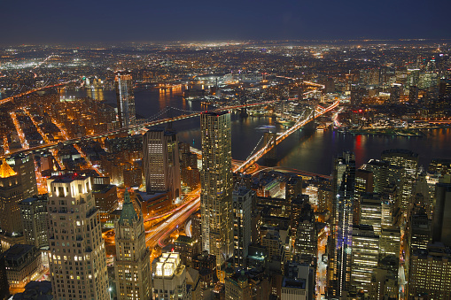 New York City illuminated at night, Manhattan and Brooklyn with East River, Manhattan Bridge and Brooklyn Bridge, aerial view.