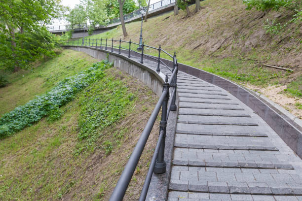 istock Paved path with railings on hillside in summer city park 1457465693