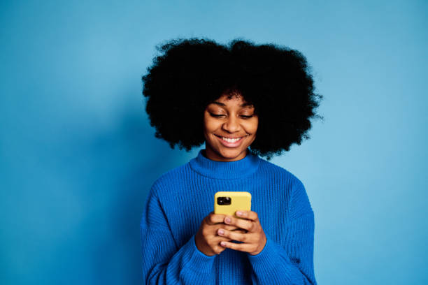 istock Cheerful black woman using smartphone 1457466991