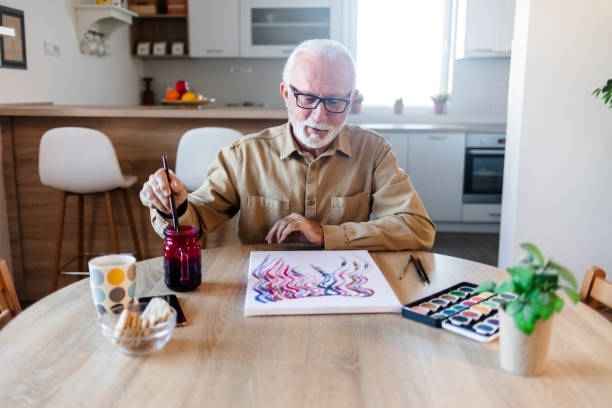 istock Elderly man is painting in her home. Retirement hobby. 1457467521