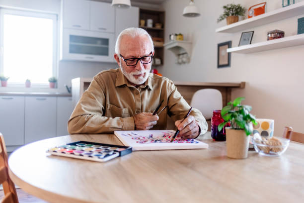 istock Happy senior man painting. 1457468376