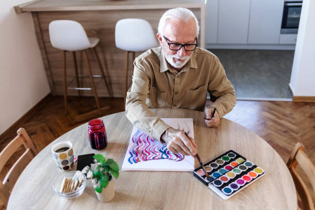 istock Mature man painting at home. 1457468424