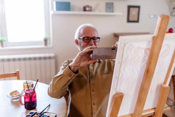 istock Senior man at home painting. 1457469430